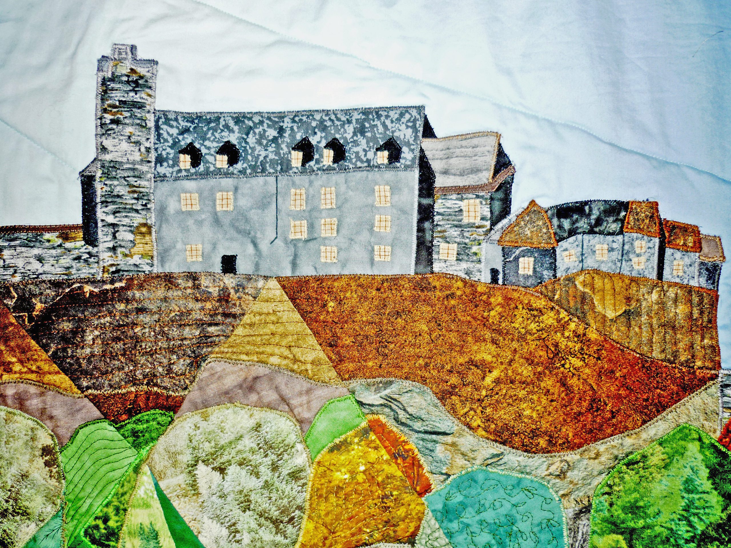 Quilting details showing Stirling Castle with many different fabrics outlined in embroidery stitching