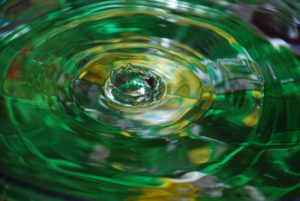 Water droplet reflection in a pool of green