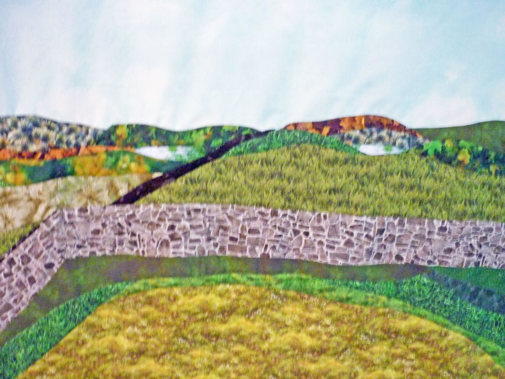 Piecing a quilted landscape of the hills and stone wall surrounding Kildalton Abbey