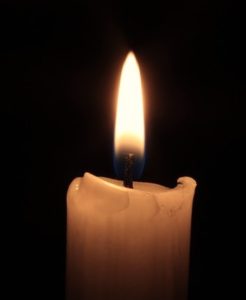 Flickering candle flame against a dark black background