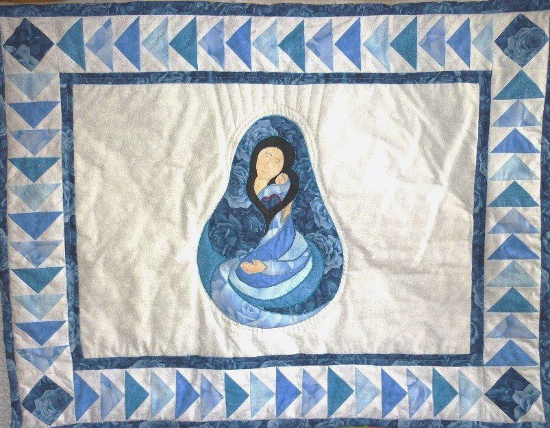 Beautiful Madonna and Child quilt framed in a traditional Flying Geese border with blue tonal fabrics and finely detailed hand-quilting