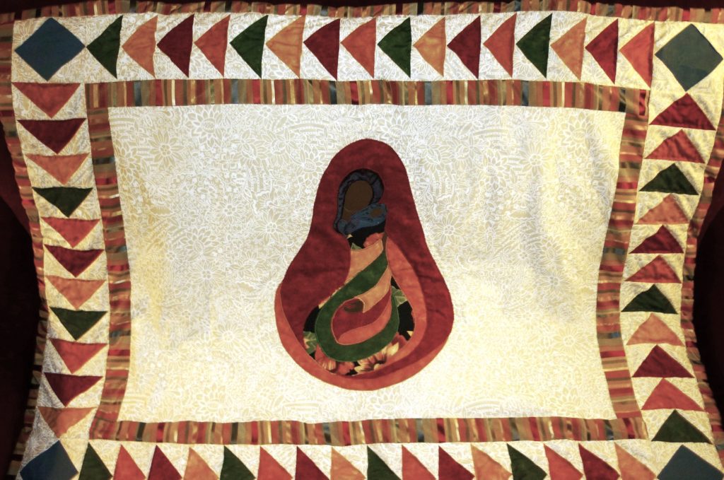 Beautiful quilt of a Madonna and Child of colour using bright vibrant fabrics