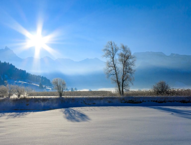 Sun sparkling on a peaceful winter landscape of snow