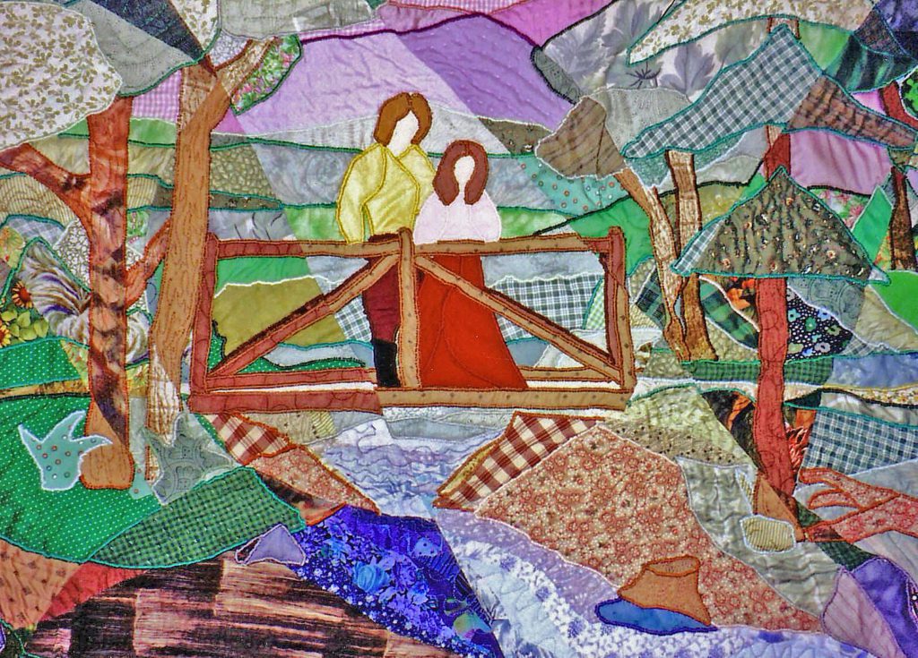 Quilt of a couple standing across a bridge using a wide array of coloured fabrics and threads