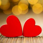 Two tiny red hearts against a golden-hued background