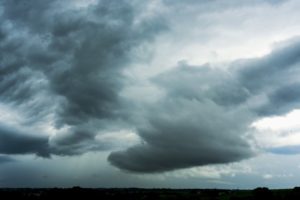 Dark storm clouds gathering across a bleak landscape