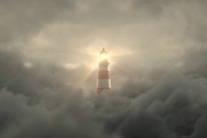 Lighthouse beacon shining thru the fog and clouds