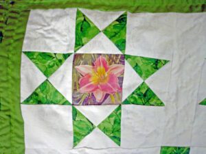 Ohio Star quilt block with a snap dragon stitched into the center