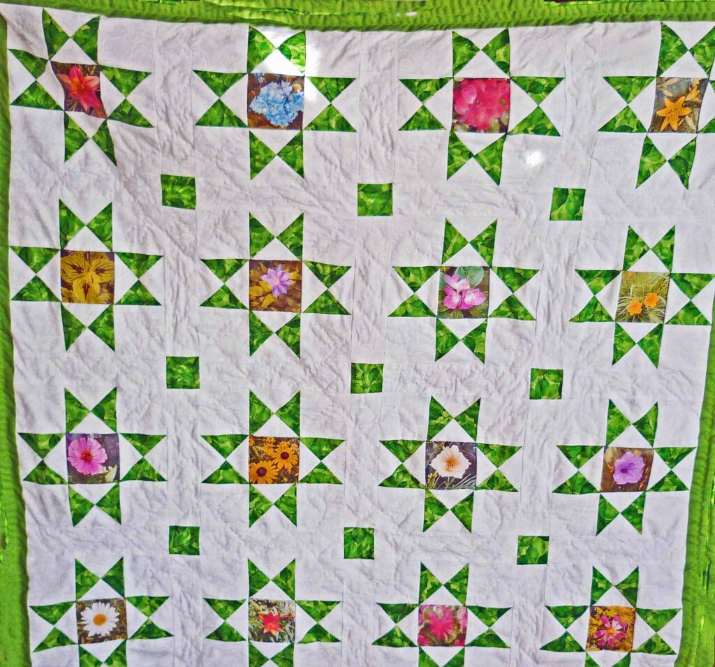 Traditional Ohio Star quilt with 16 stars and flowers sewn into the center of the blocks