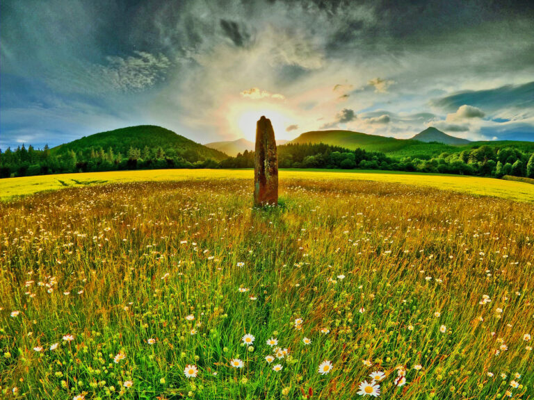 Summer Solstice; the rising sun over a stone monolith