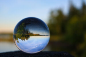 Summer lakeshore scene displayed through a transparnt glass ball in Cold Lake, Alberta
