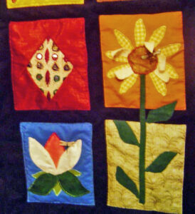 Various appliqued designs including a sunflower in 3-D and a lotus flower