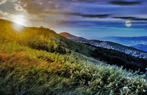 Day and night time change concept in mountain landscape. grassy meadow on a hillside with sun and full moon