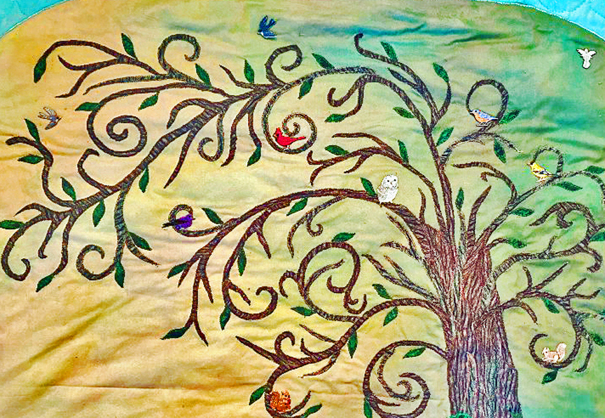 Birds nesting within the branches of a quilt depicting the Tree of Life