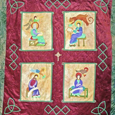 Quilt of the four evangelists from the Lindisfarne Gospels on a burgundy background framed in a Celtic knot design