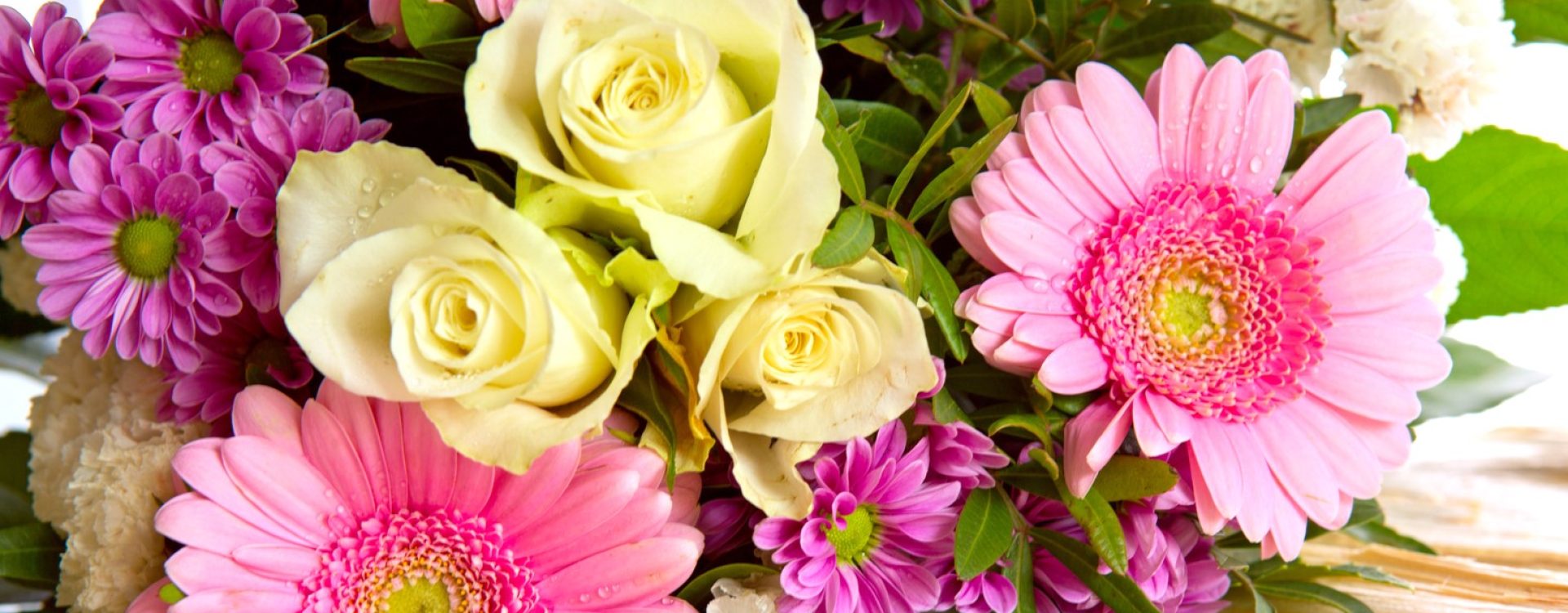 A bouquet of yellow roses and pink daisies