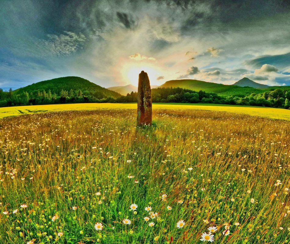 Summer Solstice; the rising sun over a stone monolith