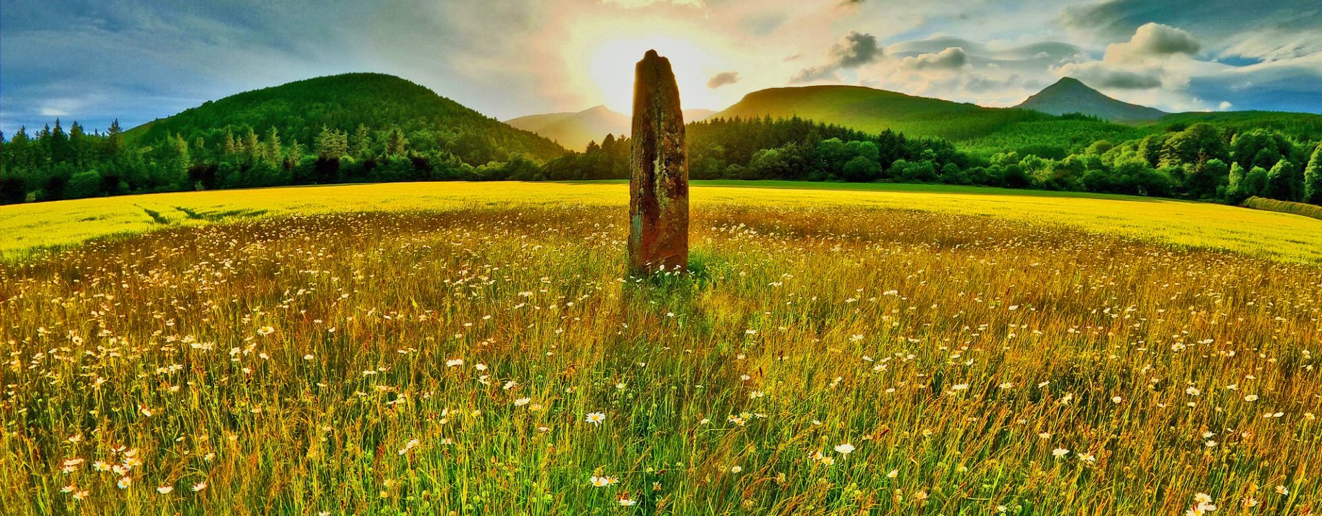 Summer Solstice; the rising sun over a stone monolith