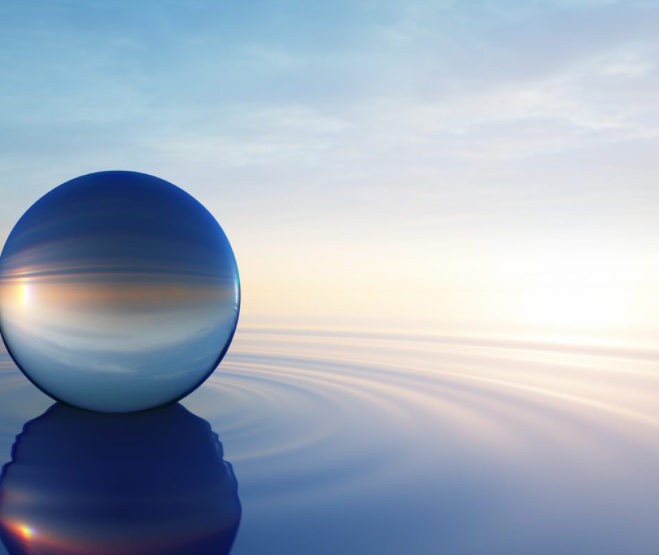 Glass sphere in calm ocean with evening sun with horizon - tranquil scenery