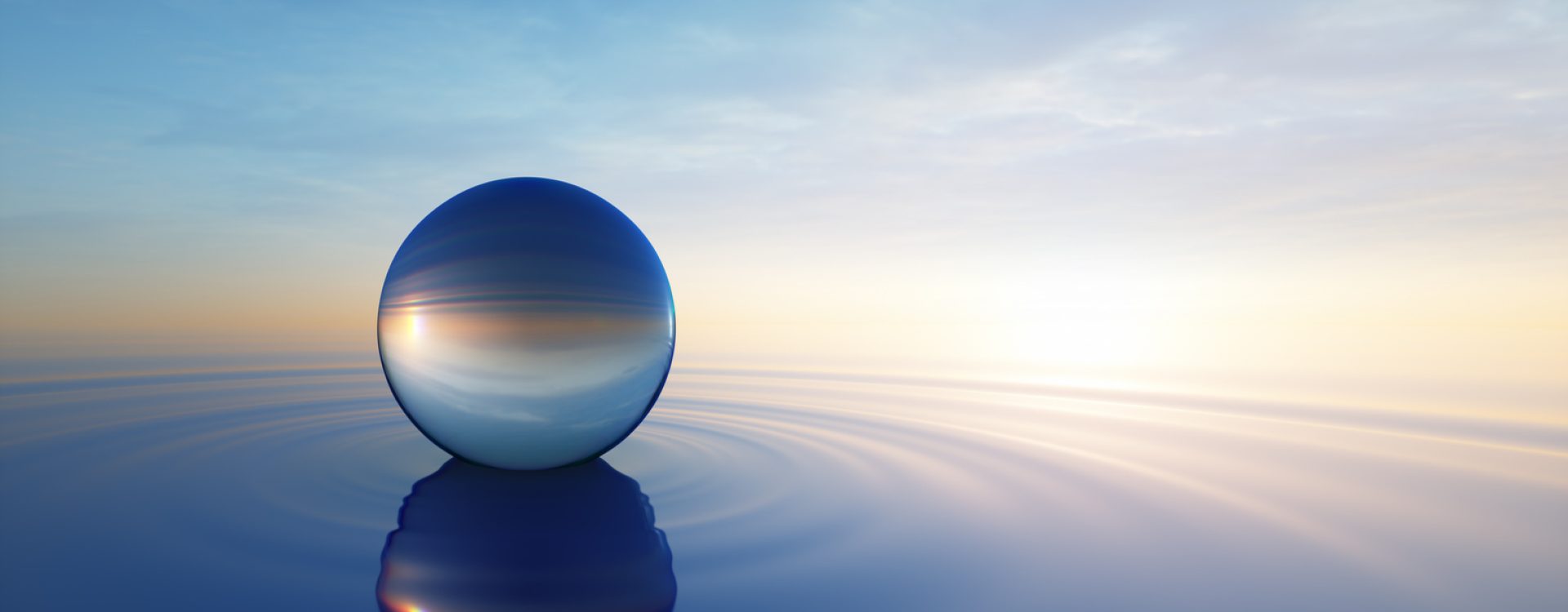 Glass sphere in calm ocean with evening sun with horizon - tranquil scenery