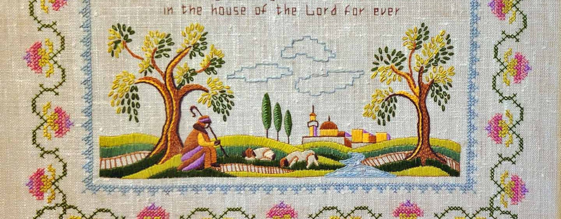 Cross-stitch sampler of the 23rd Psalm with a pink rose border