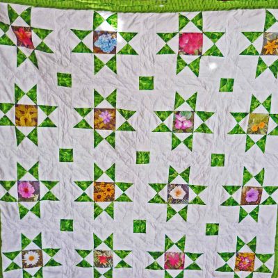 Traditional Ohio Star quilt with 16 stars and flowers sewn into the center of the blocks