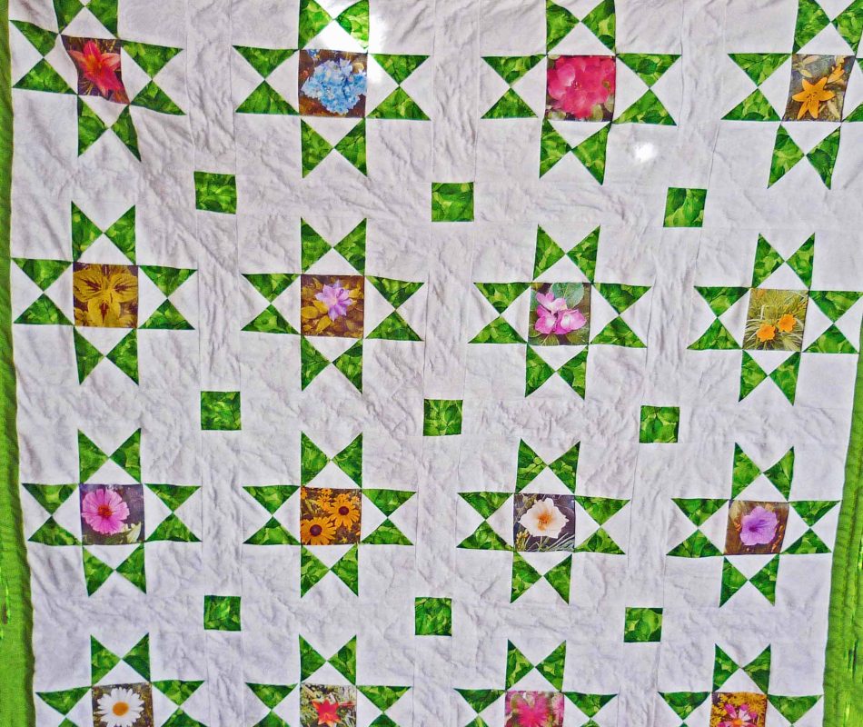 Traditional Ohio Star quilt with 16 stars and flowers sewn into the center of the blocks